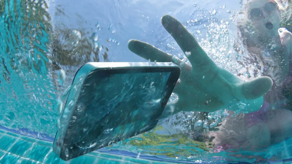 Woman dropping smartphone in pool