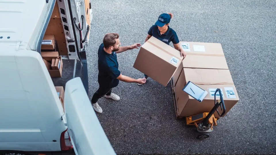 co-workers loading packages onto a delivery van