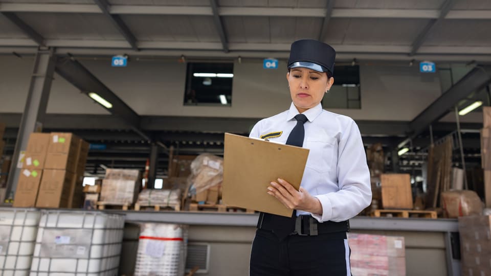 government worker taking notes on a clip board at a distribution center