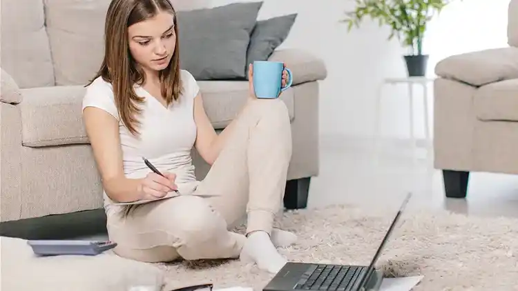 Woman sitting with a laptop and paper