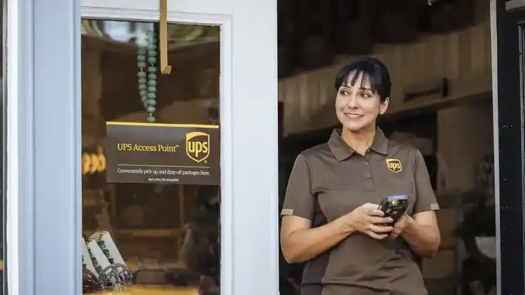 A woman UPS driver leaving a UPS Access Point