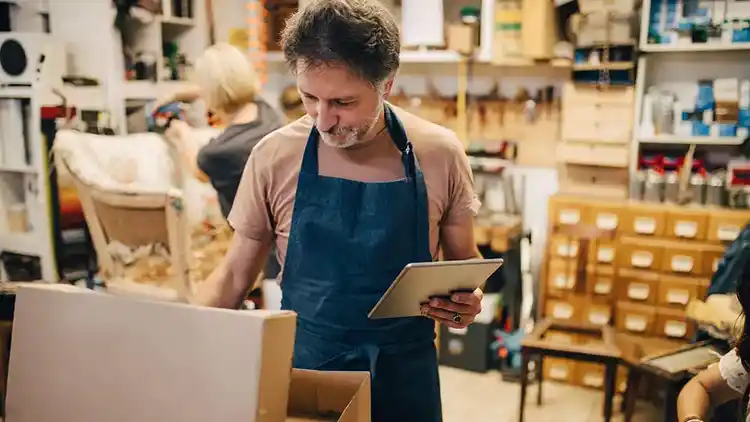 Man working in a retail store on tablet tracking parcels with UPS My Choice.