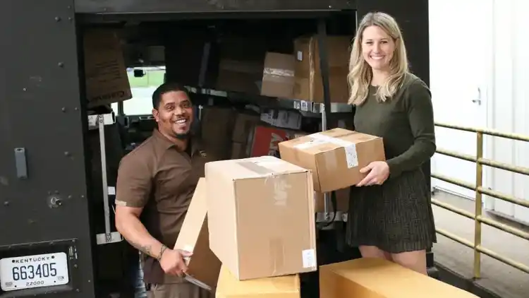 a U P S driver helping a customer unload boxes from a U P S truck