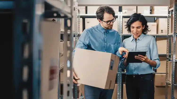 People in warehouse surrounded by boxes